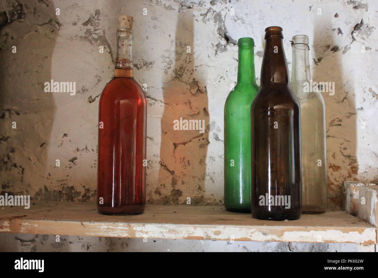 Bottiglie di vetro su uno scaffale in una cantina in una tarda estate. Foto Stock
