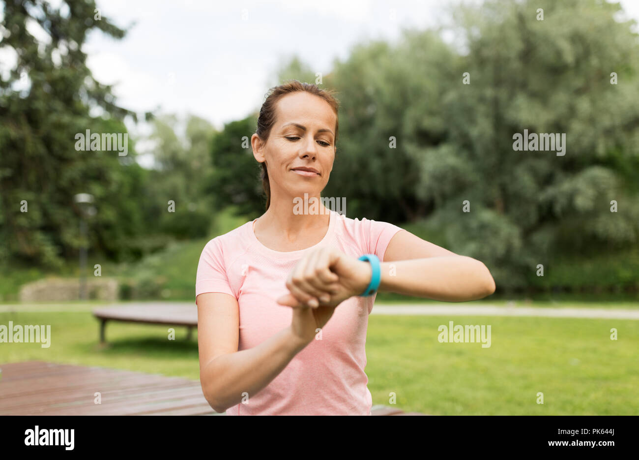 Donna con tracker di fitness in posizione di parcheggio Foto Stock