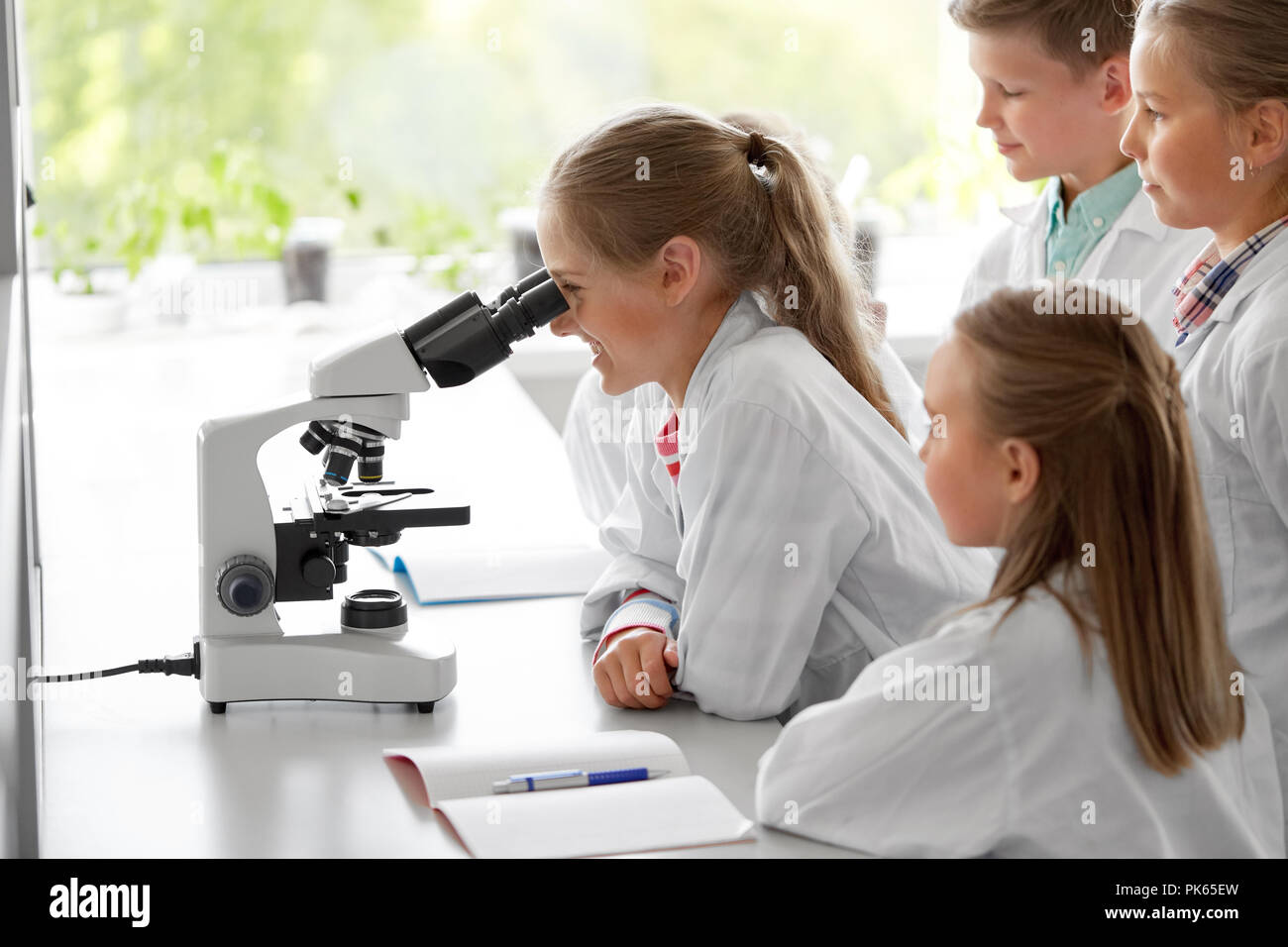 I ragazzi o studenti di biologia microscopio a scuola Foto Stock