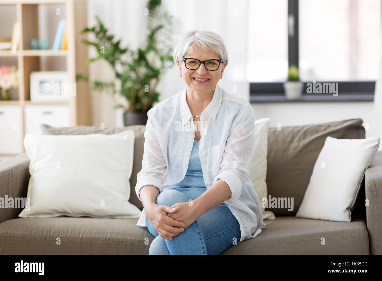 Ritratto di felice donna senior in bicchieri a casa Foto Stock