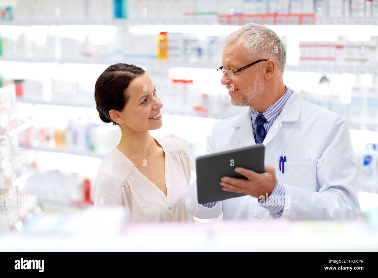 Il farmacista e il cliente con i tablet pc in farmacia Foto Stock