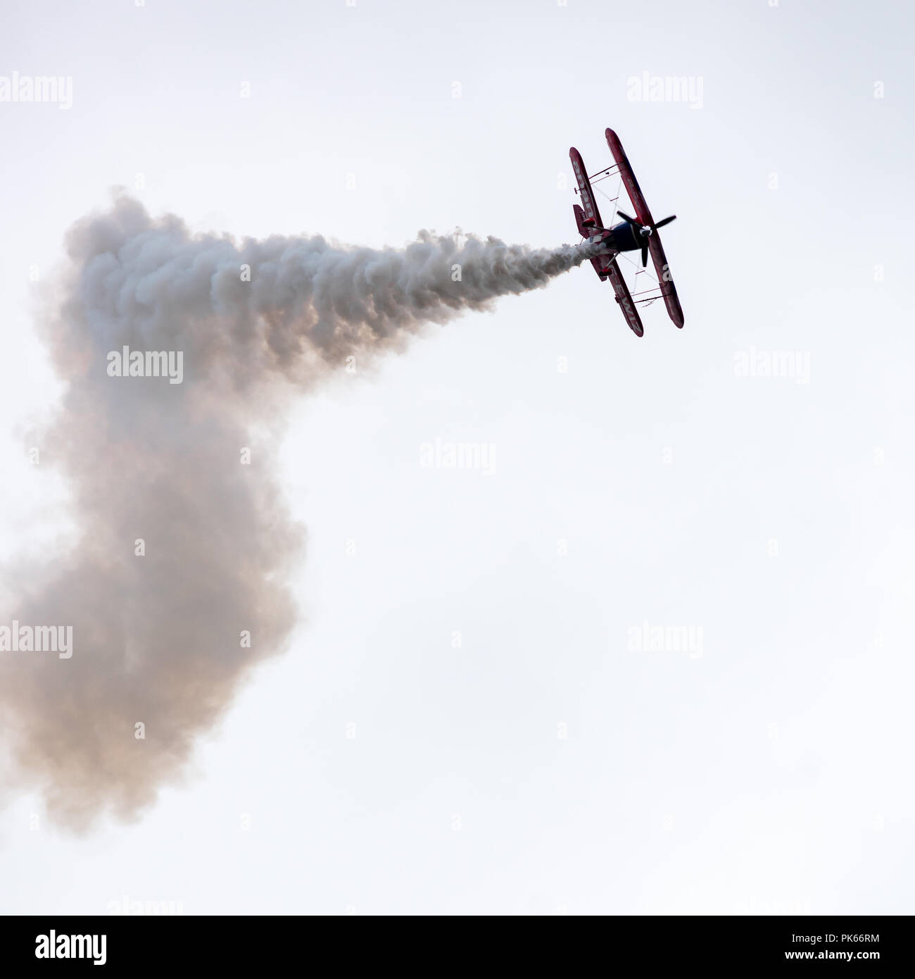Fumo denso flutti da un Pitts Special S2S biplano durante un display di acrobazia aerea Foto Stock