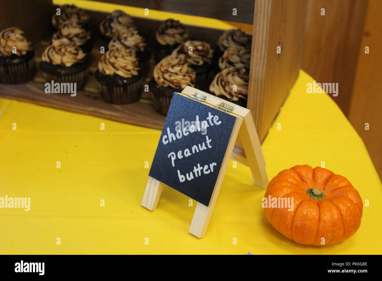Il cioccolato burro di arachidi tortine in una cassa in decorate rientrano nella tabella con un piccolo segno della lavagna e zucca Foto Stock