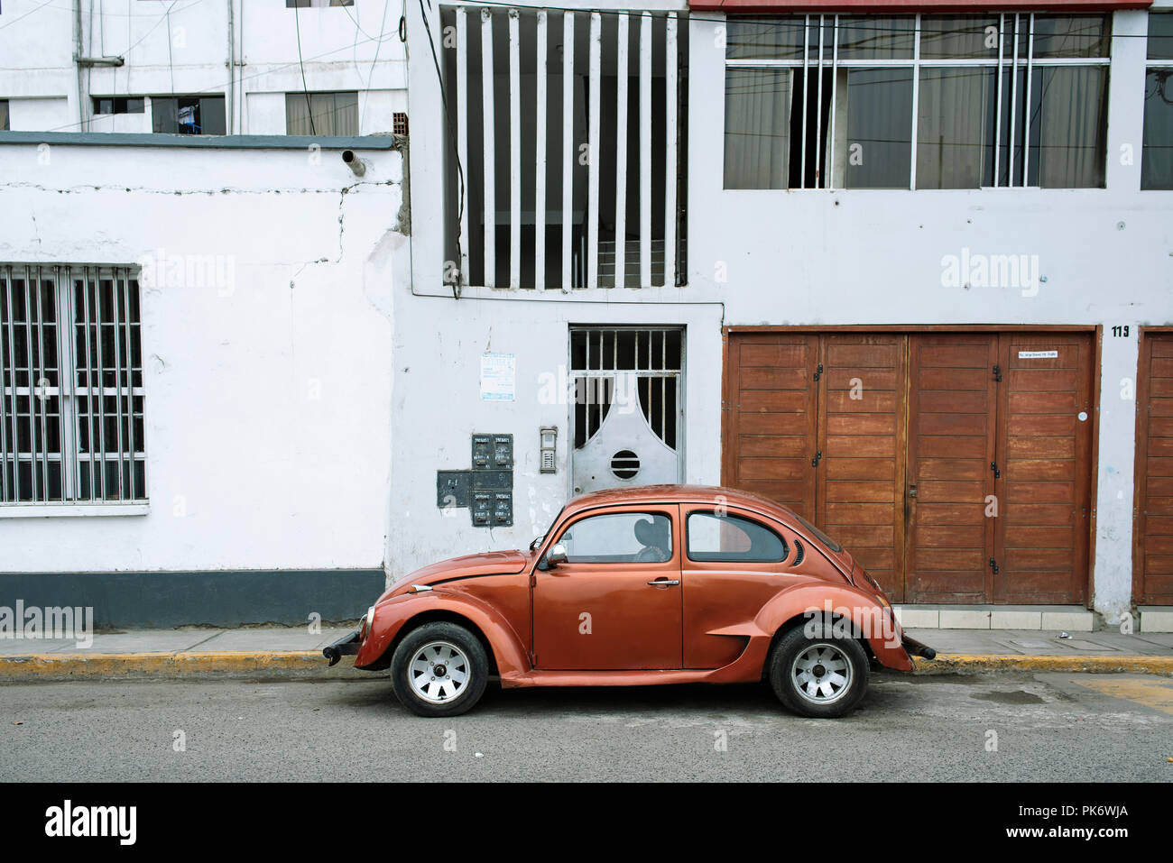 Elegante vintage beetle parcheggio accanto a edifici residenziali. Coloratissima scena urbana in Trujillo, Perú. Lug 2018 Foto Stock
