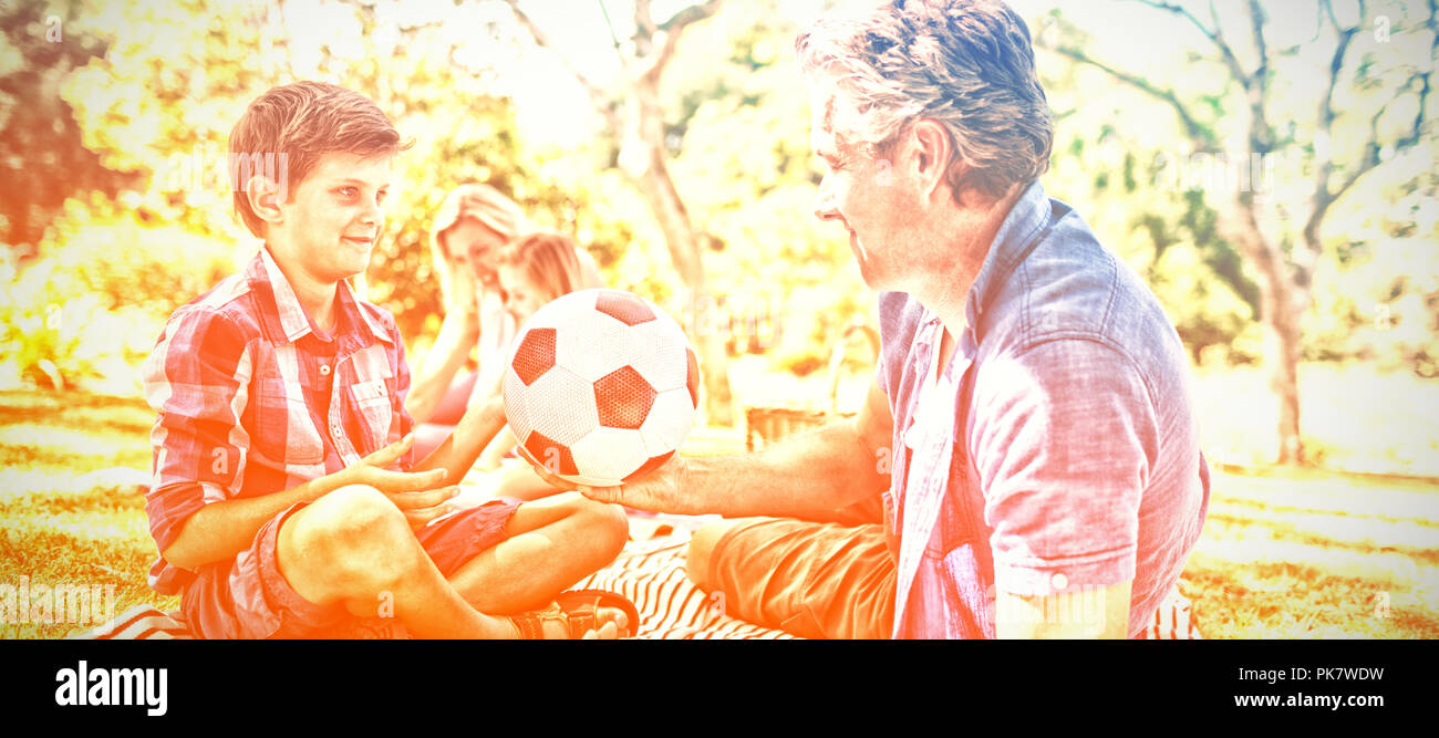 Padre e figlio giocando con il calcio in posizione di parcheggio Foto Stock