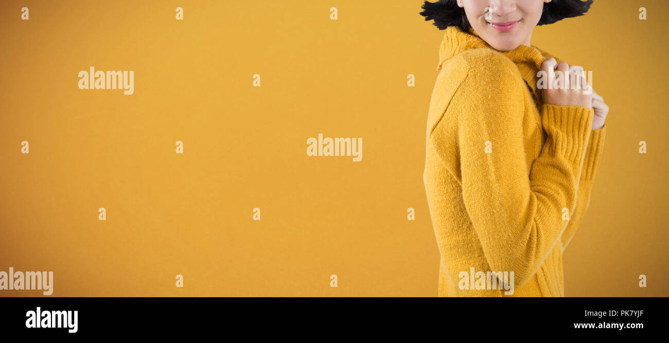 Immagine composita della donna in abiti invernali in posa contro uno sfondo bianco Foto Stock