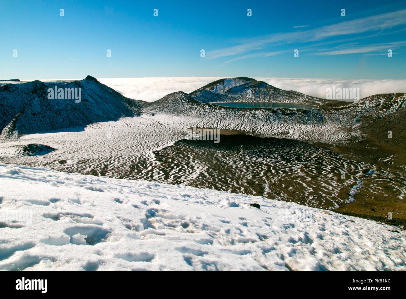 Ultramarini blu profondo lago sotto la cima delle montagne in alta grandezza la mozzafiato attivo selvaggio paesaggio vulcanico coperto di neve, Nuova Zelanda Foto Stock