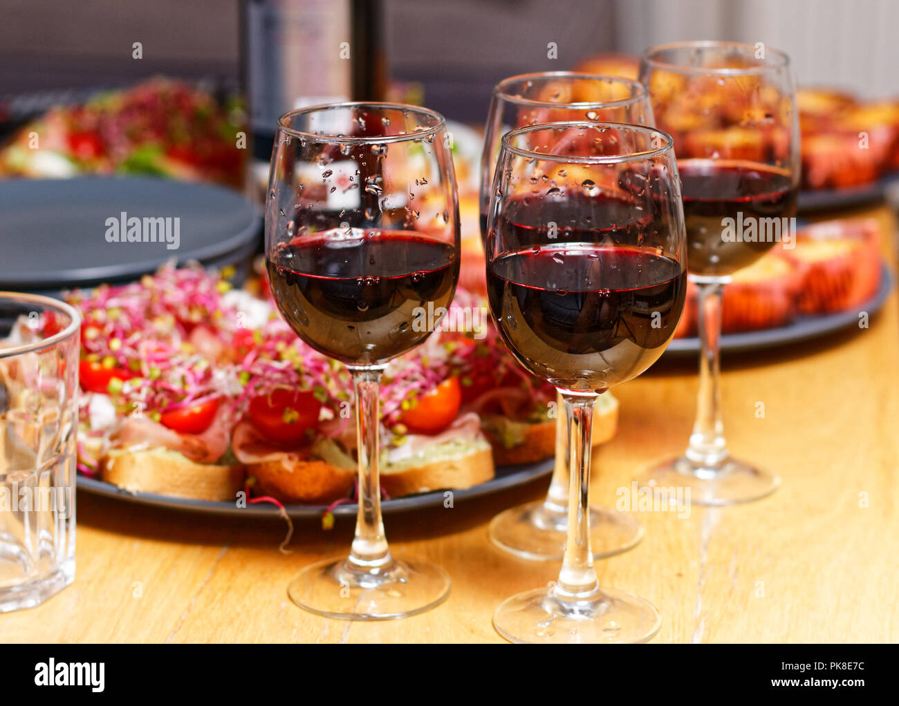 House Party - 4 bicchieri di vino rosso, panini e dolci Foto Stock