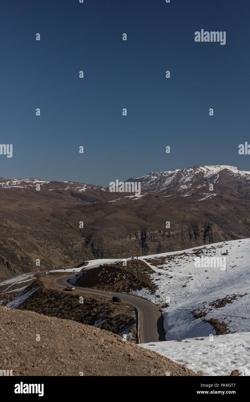 Strada di Valle Nevado Resort per sci e snowboard, questo modo è tra montagne innevate dove le persone parcheggio e godere di praticare gli sport invernali Foto Stock