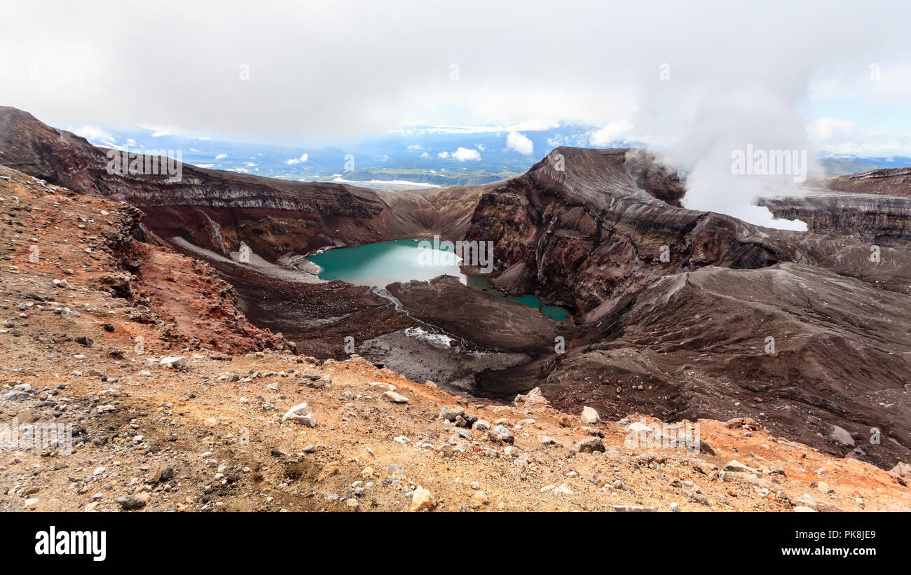Vista del vulcano Gorely nella cortina di nubi meteo, penisola di Kamchatka, Russia Foto Stock