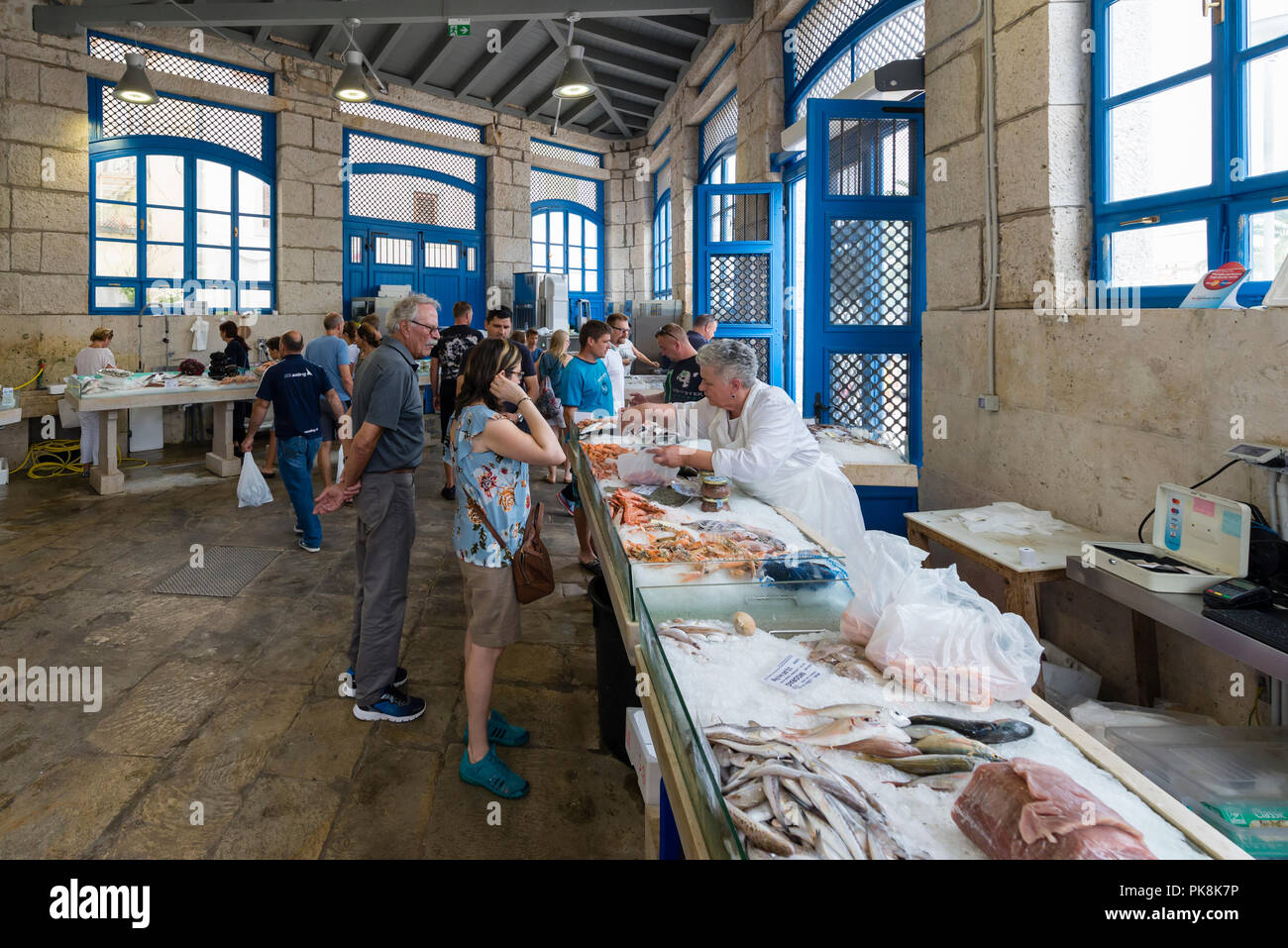 Una commessa serve un cliente al mercato del pesce nel mercato coperto di Mali Lošinj Isola di Lussino, baia di Kvarner, Croazia Foto Stock