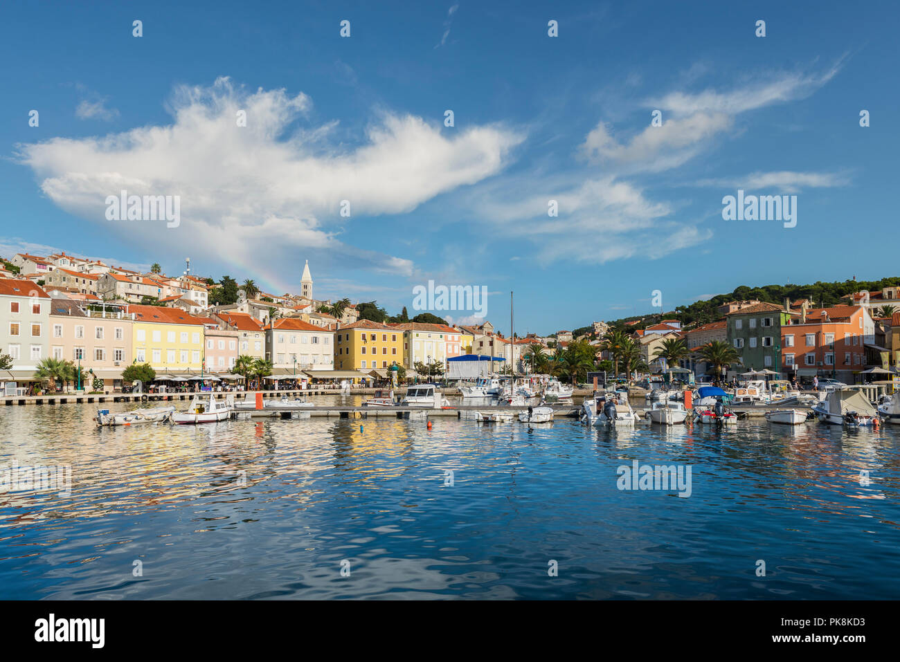 Il cloud di arcobaleno sopra il porto di Mali Lošinj nel golden luce della sera, isola di Lussino, baia di Kvarner, Croazia Foto Stock