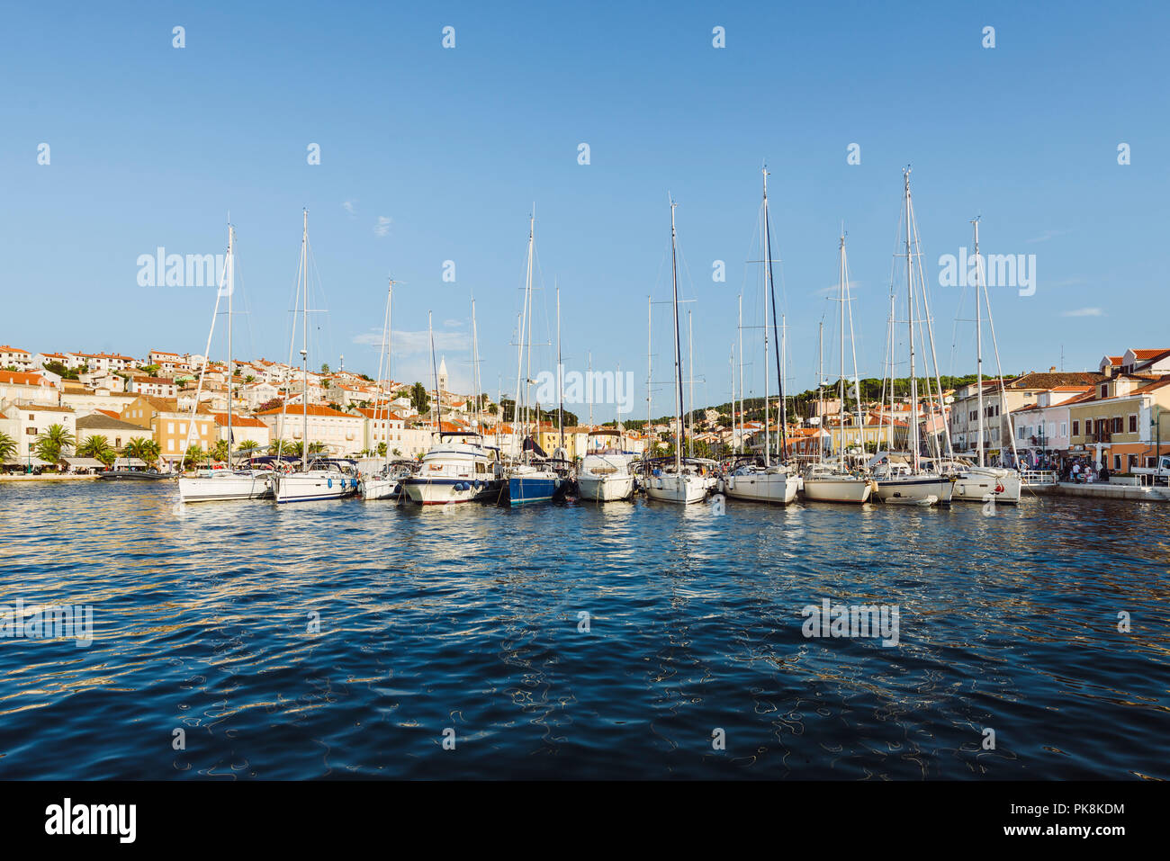 Barche a vela e yacht ormeggiati nel porto di Mali Lošinj nella calda luce della sera, isola di Lussino, baia di Kvarner, Croazia Foto Stock
