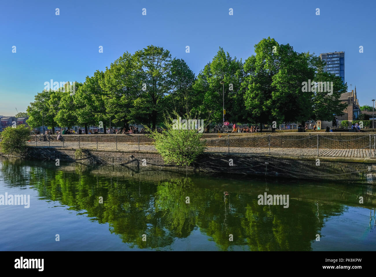 Shadwell bacino, London, Regno Unito - 7 maggio 2018:vista orizzontale della Shadwell bacino con la passerella e le persone che si godono la giornata di sole. Shot mostra incantevole refec Foto Stock