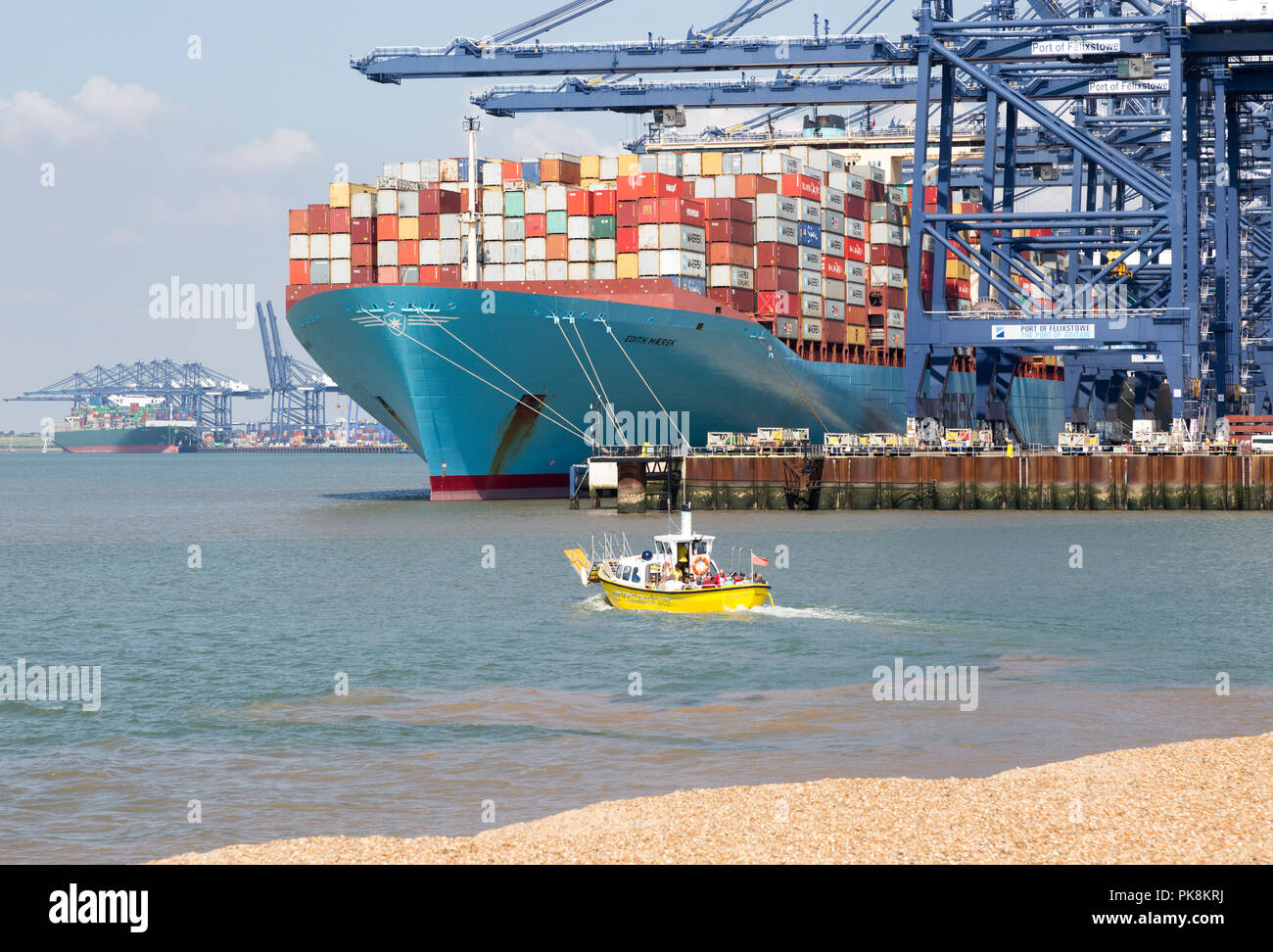 Piccoli piedi passeggero ferry boat sopraffatte da enormi Edith Maersk Container ship, porto di Felixstowe, Suffolk, Inghilterra, Regno Unito Foto Stock