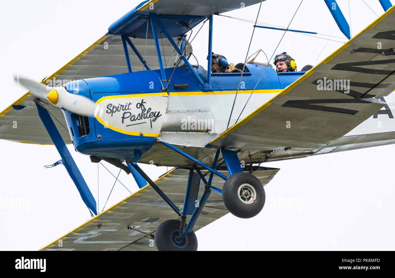 Spirito di Pashley, G-AMNN, a 2 posti motore singolo Tiger-Moth Bi-plane volare basso come si entra in terra nel sud del Regno Unito. Foto Stock