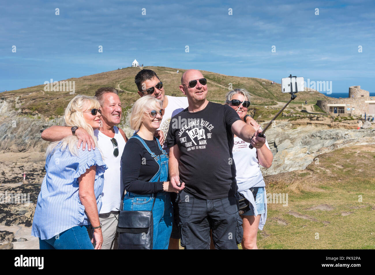 Un gruppo di vacanzieri felici in una vacanza di staycation in posa per una foto selfie sulla costa a Newquay Cornwall. Foto Stock