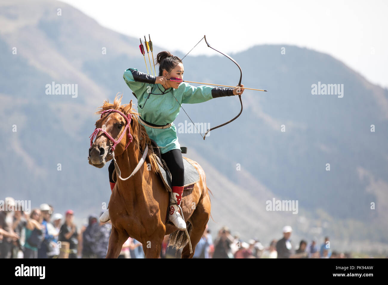 Città Cholpon-Ata, Kirghizistan - Settembre 6, 2018: Femmina archer mirando a un bersaglio durante un tradizionale cavallo tiro con l'arco della concorrenza. Foto Stock