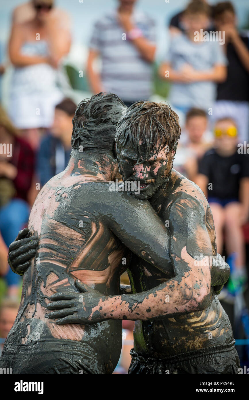 Due uomini di wrestling di fango in un combattimento di fango sulla concorrenza nella pianura di giochi in Thorney Somerset Foto Stock