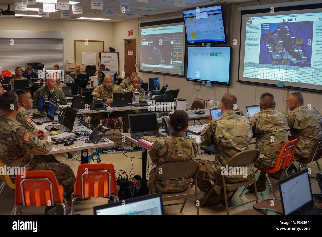 I membri del servizio con Joint Task Force 5-0 ricevere un quotidiano del comandante breve aggiornamento, agosto 25, 2018 l'esercito Hawaii National Guard Centre al Diamond Head, Honolulu, Hawaii, 24 agosto 2018. JTF 5-0 è una joint task force guidata da un doppio stato comandante che è istituito per rispondere agli effetti dell'Uragano Lane sullo stato delle Hawaii. I membri della task force restano impegnati a monitorare gli effetti e gli incidenti in tutto lo stato delle Hawaii per rispondere a tutte le richieste presentate dagli enti locali e dalle autorità statali attraverso la FEMA. () Foto Stock