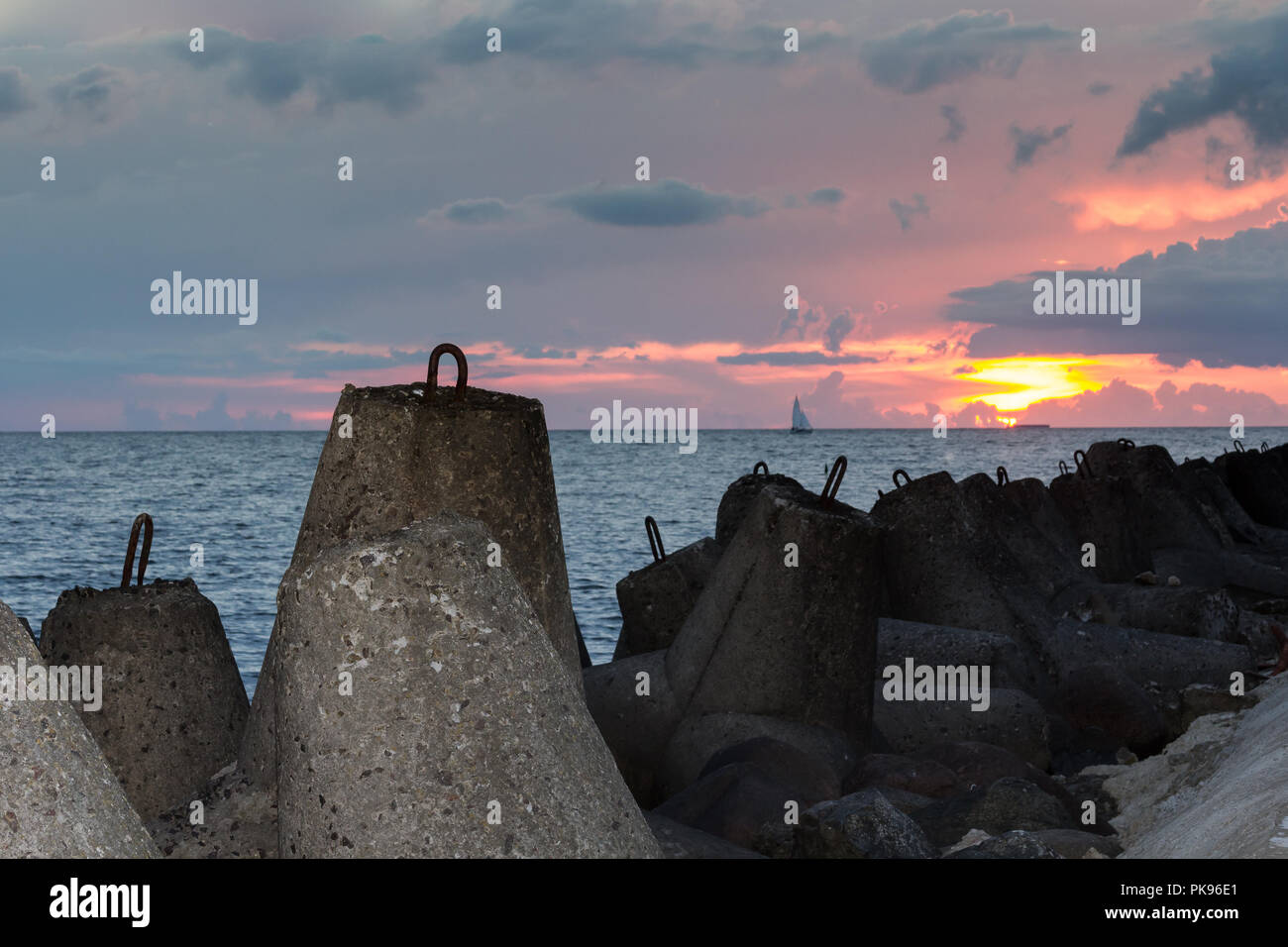 Wavebrakers granito in un golfo di Riga, Lettonia dopo il tramonto nel mese di agosto Foto Stock