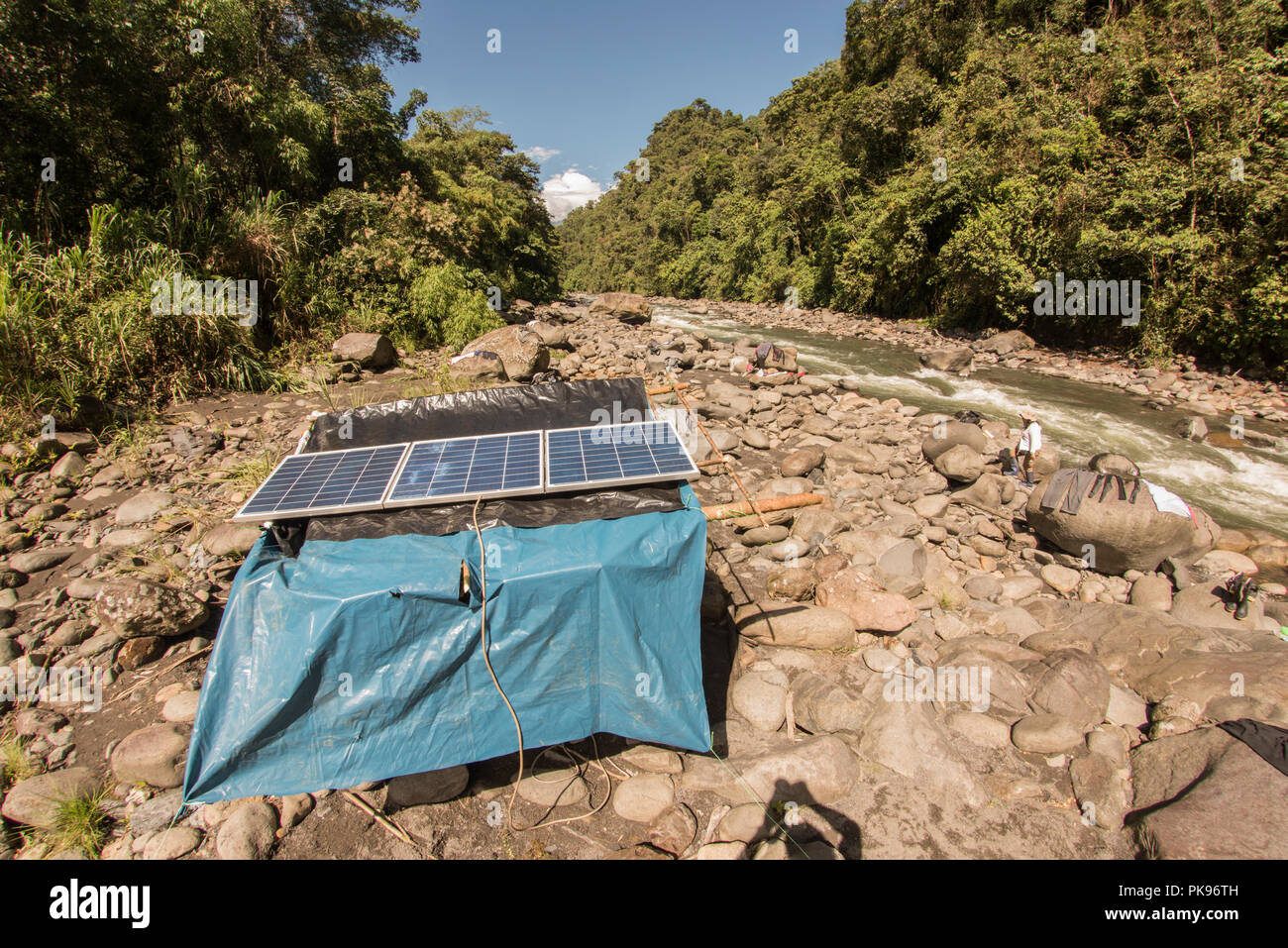 Una stazione di ricarica con pannelli solari su una riva di un fiume permette agli scienziati sulla biodiversità spedizione in remota foresta per caricare le loro apparecchiature. Foto Stock