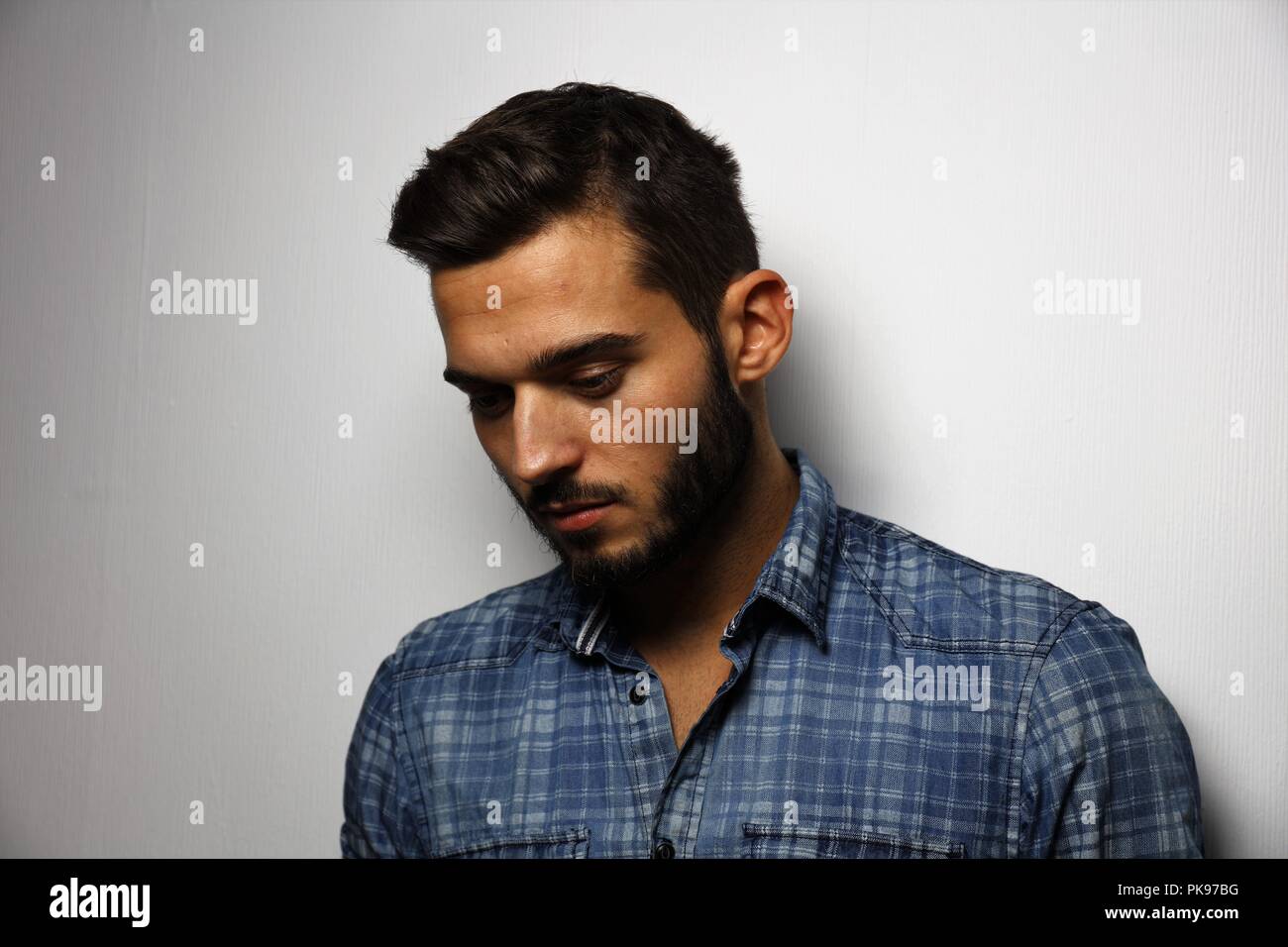Giovane uomo con la barba è pensando a qualcosa, magari wrestleling con sé, potrebbe essere capovolta o solo pensare a un problema da risolvere Foto Stock