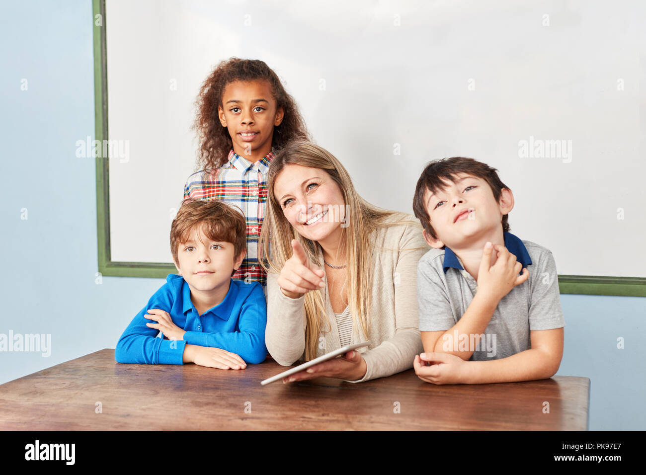 Insegnante e studente utilizzando computer tavoletta nella scuola elementare corso di informatica Foto Stock