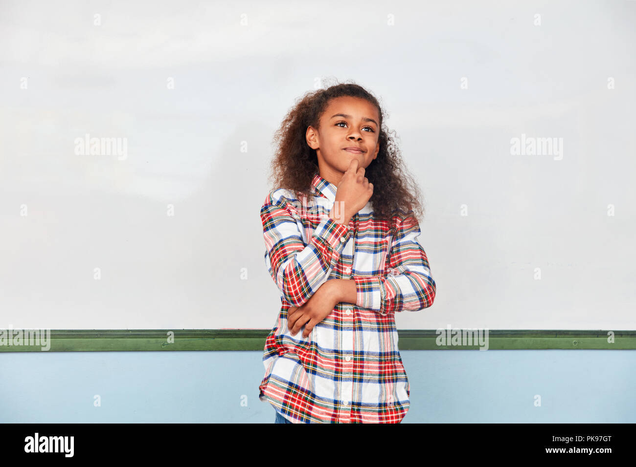 Ragazza come una scolaretta in un esame riflette su un compito Foto Stock