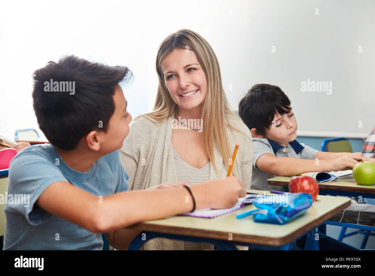 A tempo pieno maestro o insegnante di scuola elementare di tutoraggio uno studente Foto Stock