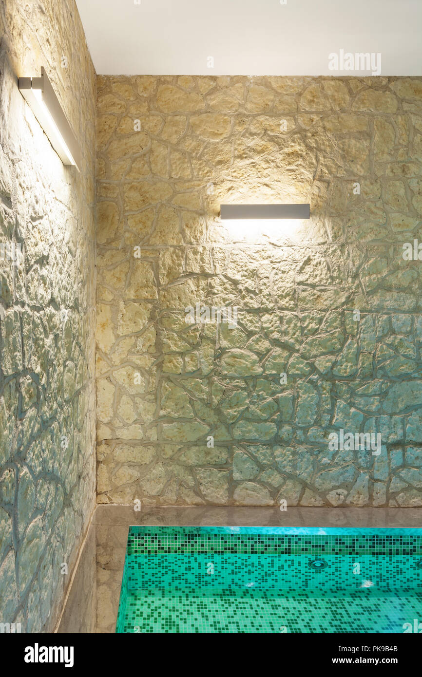 Moderno hotel spa interna, vasca calda, muro di pietra Foto Stock