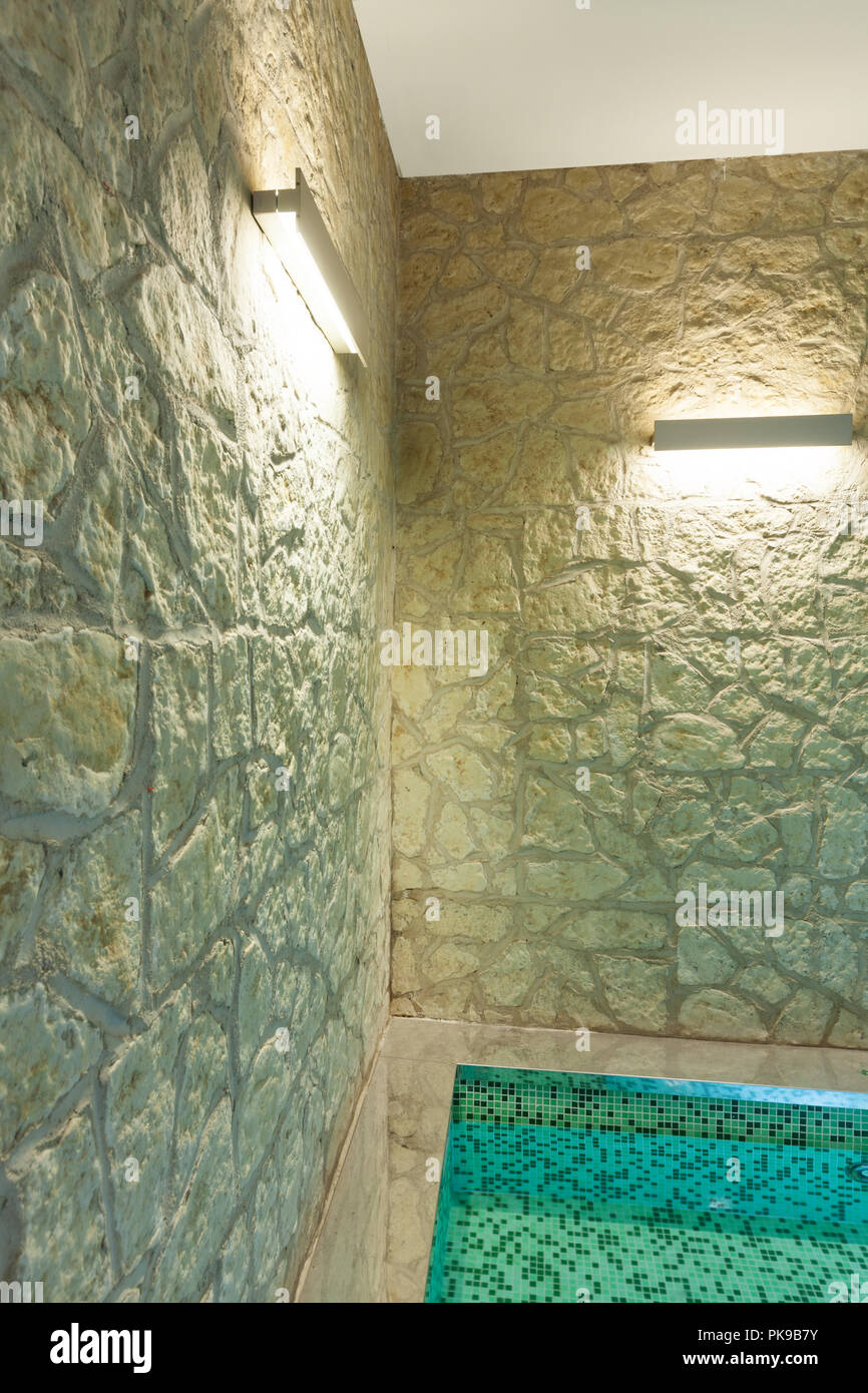 Moderno hotel spa interna, vasca calda, muro di pietra Foto Stock