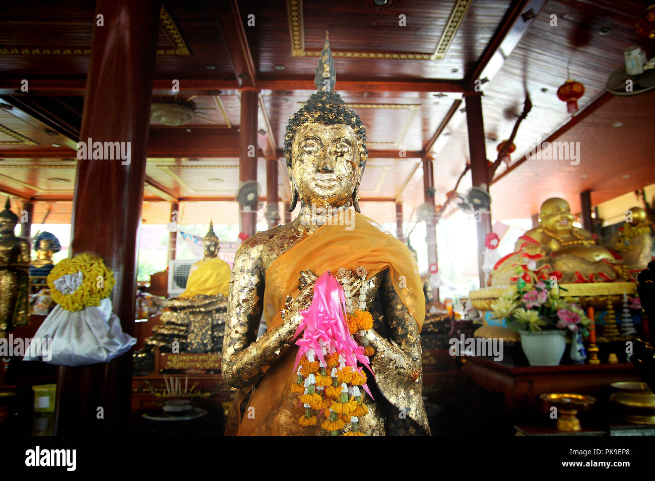 Immagine del Buddha stavano mettendo alternativamente entrambe le mani a livello del petto. Le offerte di ghirlande e doratura davanti a un'altra immagine . Foto Stock