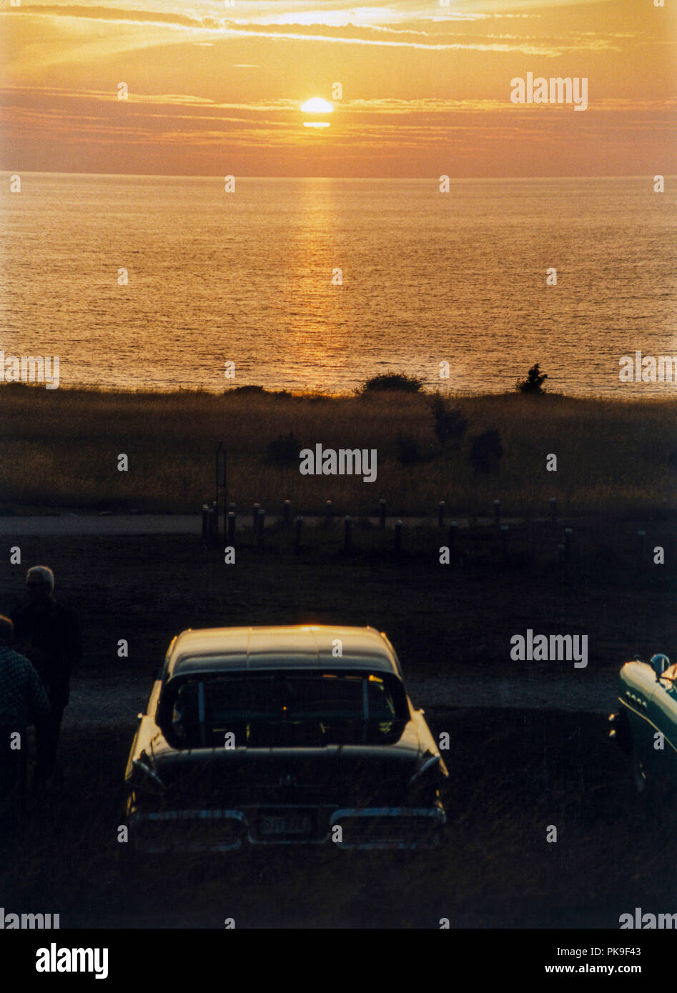 Tramonto al mare Baltico coppia romantica nelle loro automobili americane Foto Stock