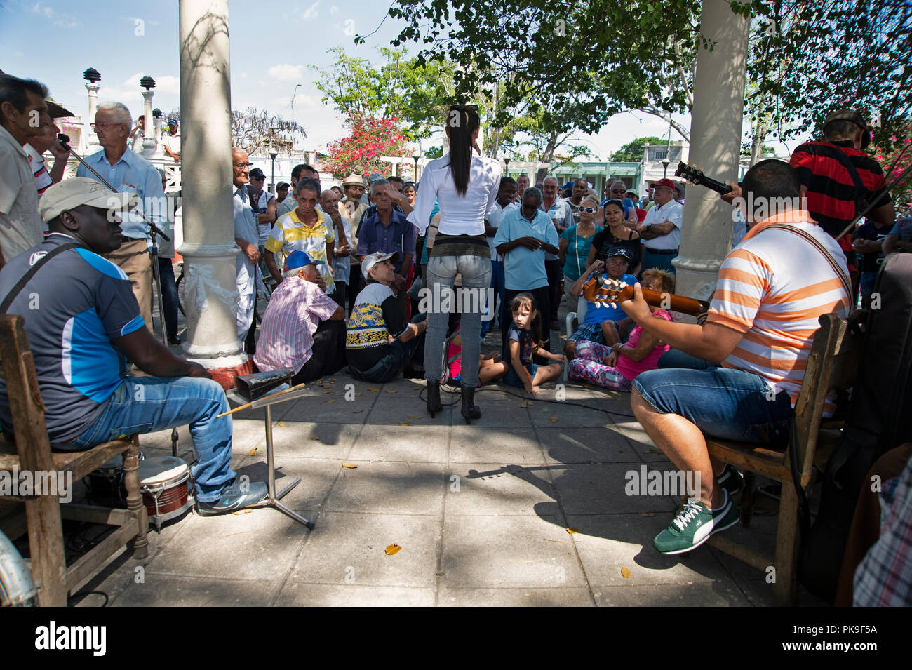 Una giovane ragazza cubana canta ad una folla di persone raccolte intorno con la sua band in una piazza di Cienfuegos Cuba Foto Stock