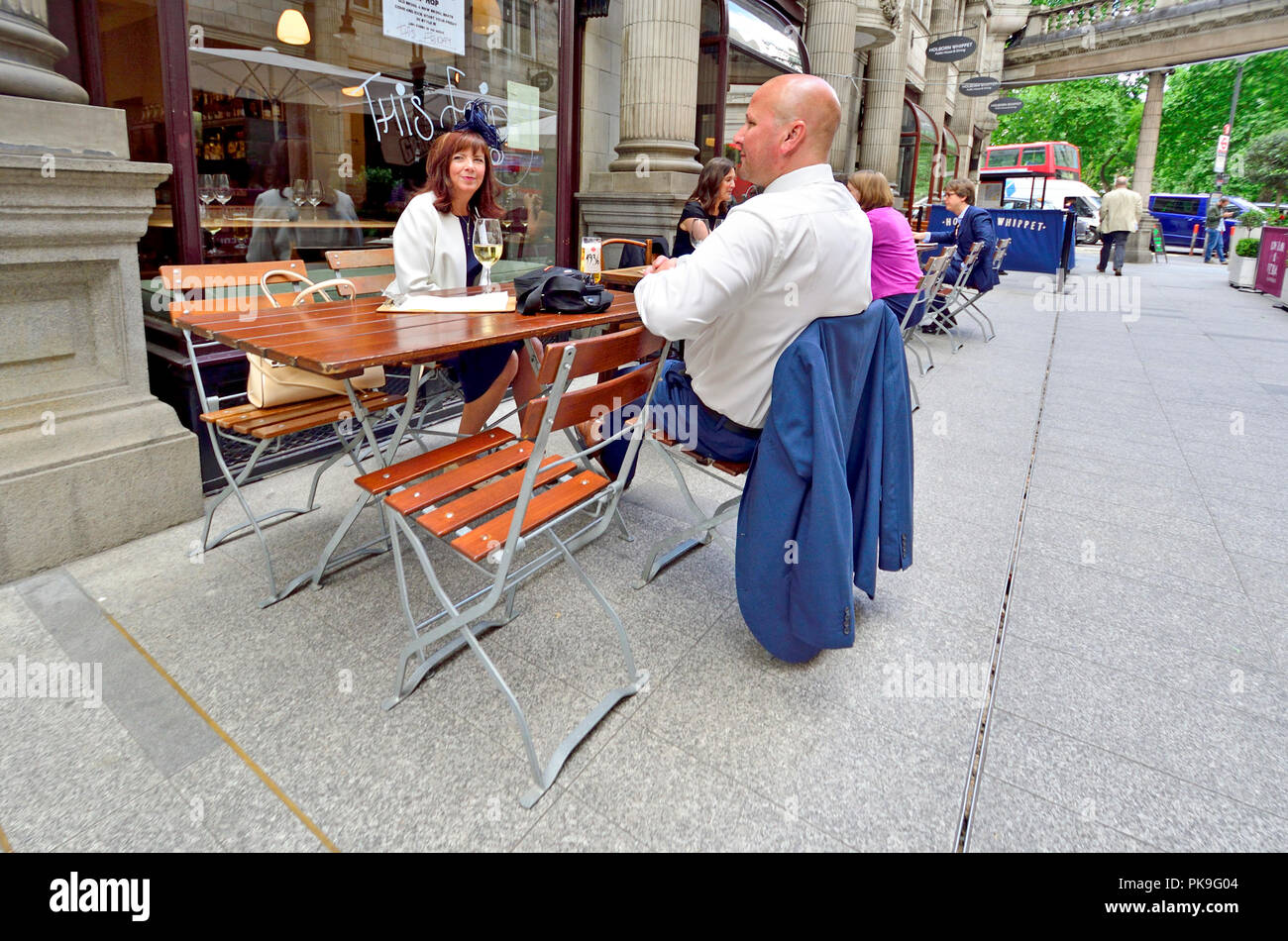 Coppia avente un drink all'aperto in siciliano Avenue, Holborn, Londra, Inghilterra, Regno Unito. Foto Stock