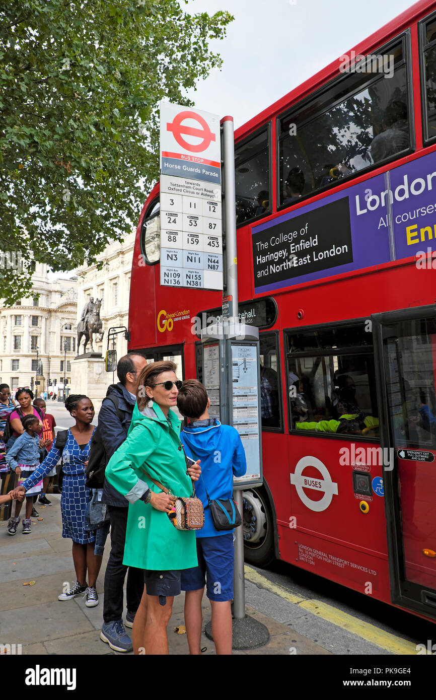 I turisti in attesa di un autobus con la sfilata delle Guardie a Cavallo al di fuori del Whitehall a Londra England Regno Unito KATHY DEWITT Foto Stock