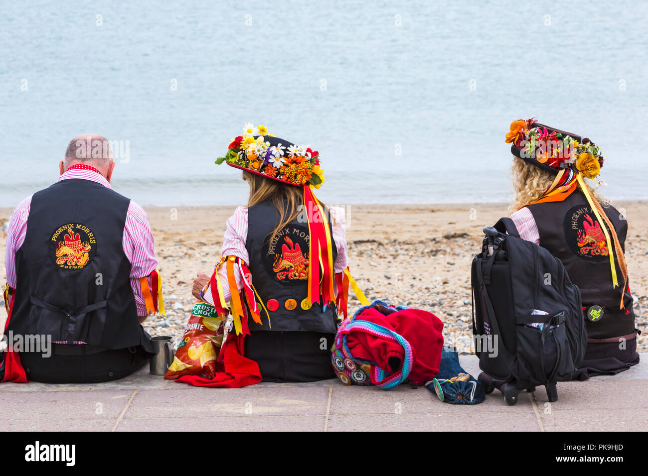 Phoenix Morris ballerini seduti sulla spiaggia a Swanage Folk Festival, DORSET REGNO UNITO su una bella calda giornata di sole nel mese di settembre Foto Stock