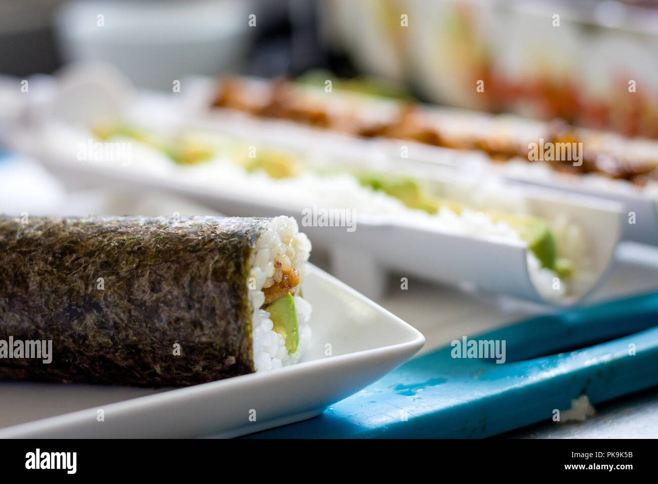 Un rotolo di freschi sushi di fronte un sushi rendendo kit Foto Stock
