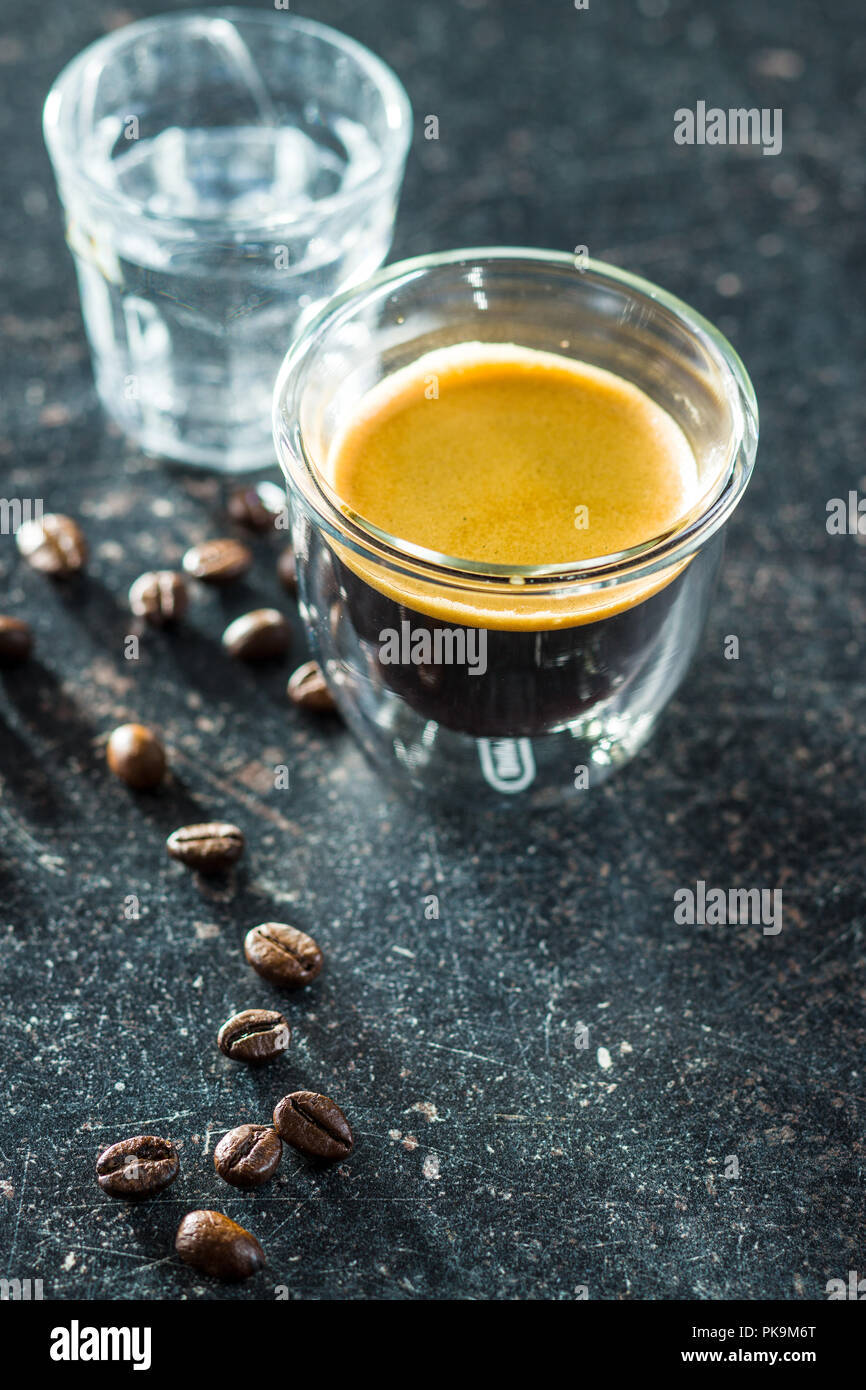 Expresso cup e i chicchi di caffè sul vecchio tavolo in legno. Foto Stock