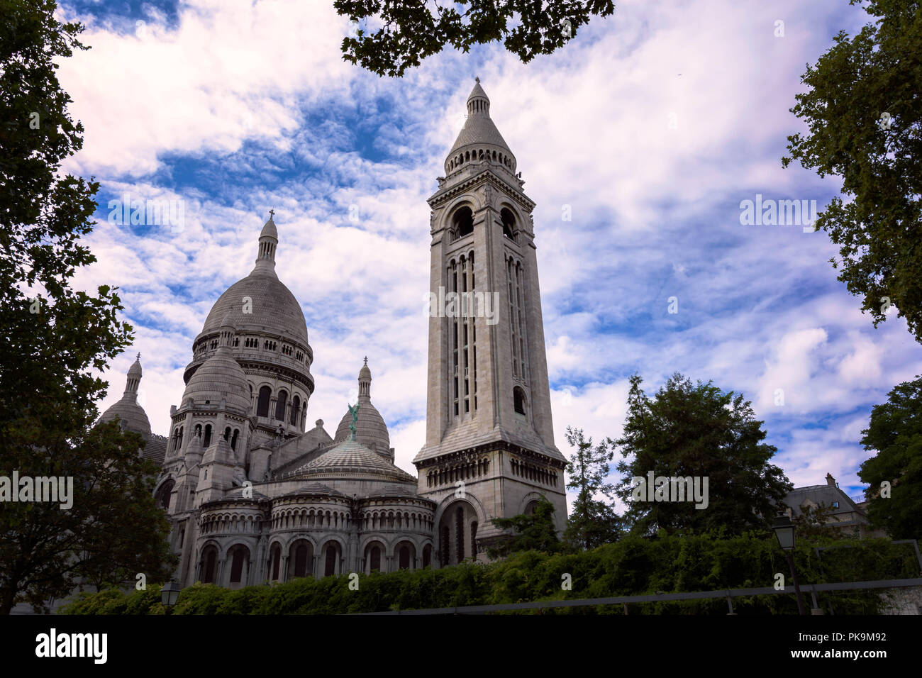 Sacré-Coeur Cattedrale di pietra calcarea di Montmartre , Parigi,Francia durante sunnyday con verde formando conopy cornice naturale Foto Stock