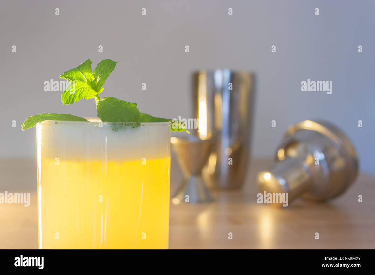 Un fresco cocktail schiumoso o frappè alla menta guarnire su un tavolo di legno o bar. Foto Stock
