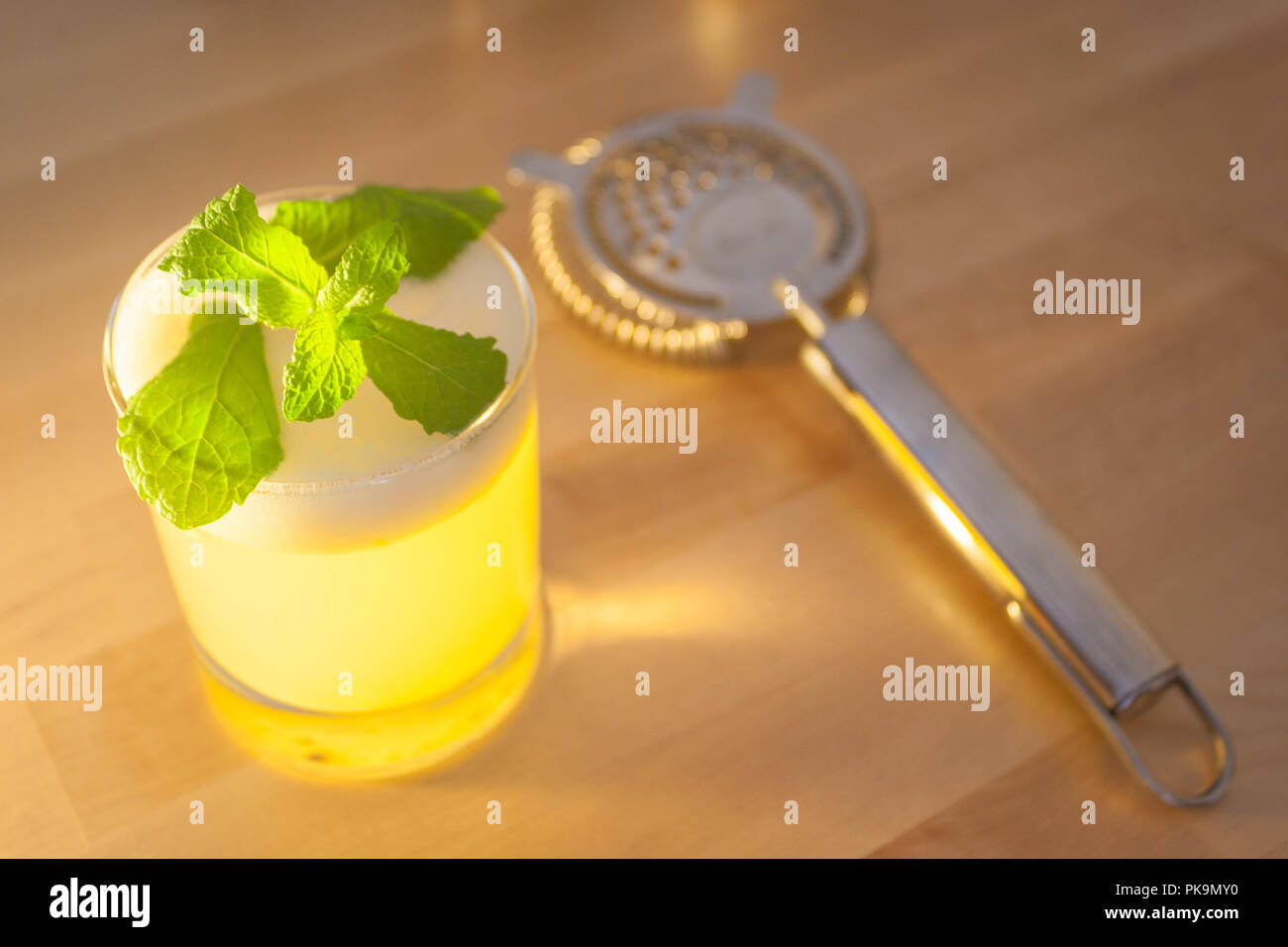 Un fresco cocktail schiumoso o frappè alla menta guarnire su un tavolo di legno o bar. Foto Stock