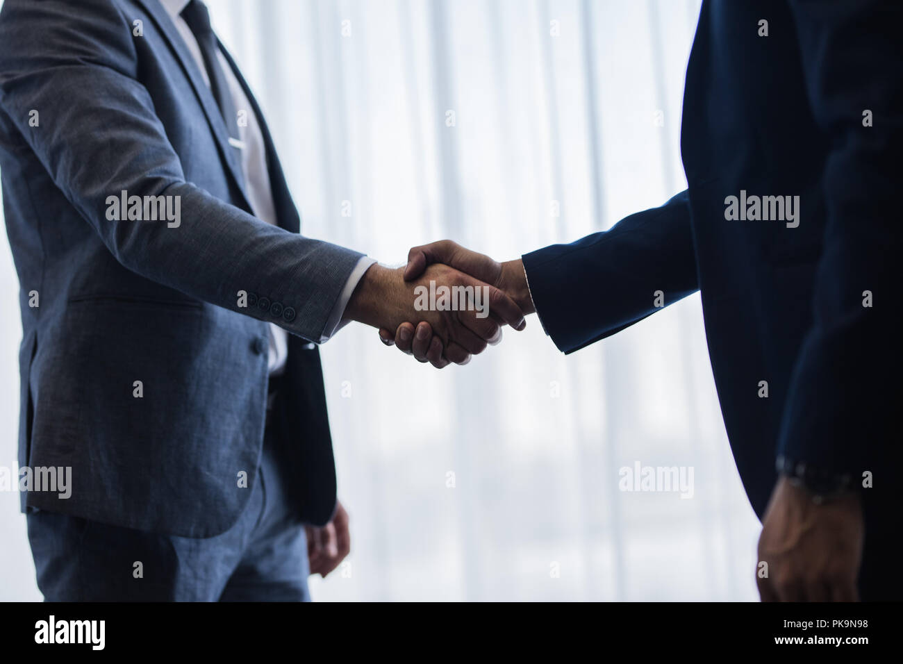 In prossimità di due imprenditori lo handshaking dopo un buon affare. La gente di affari si stringono la mano e la finitura di una riunione in ufficio. Foto Stock