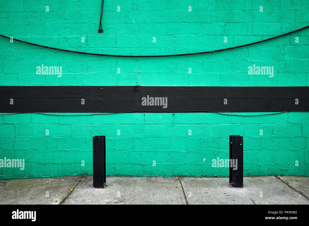 Verniciato di verde la parete in mattoni con una striscia nera, abstract background urbano, New York City. Foto Stock