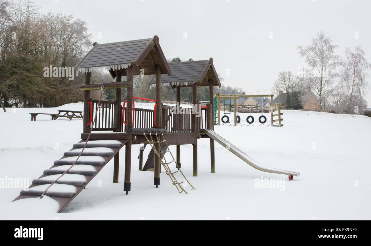 Coperta di neve parco con attrezzature per il gioco dopo la tempesta Emma Foto Stock