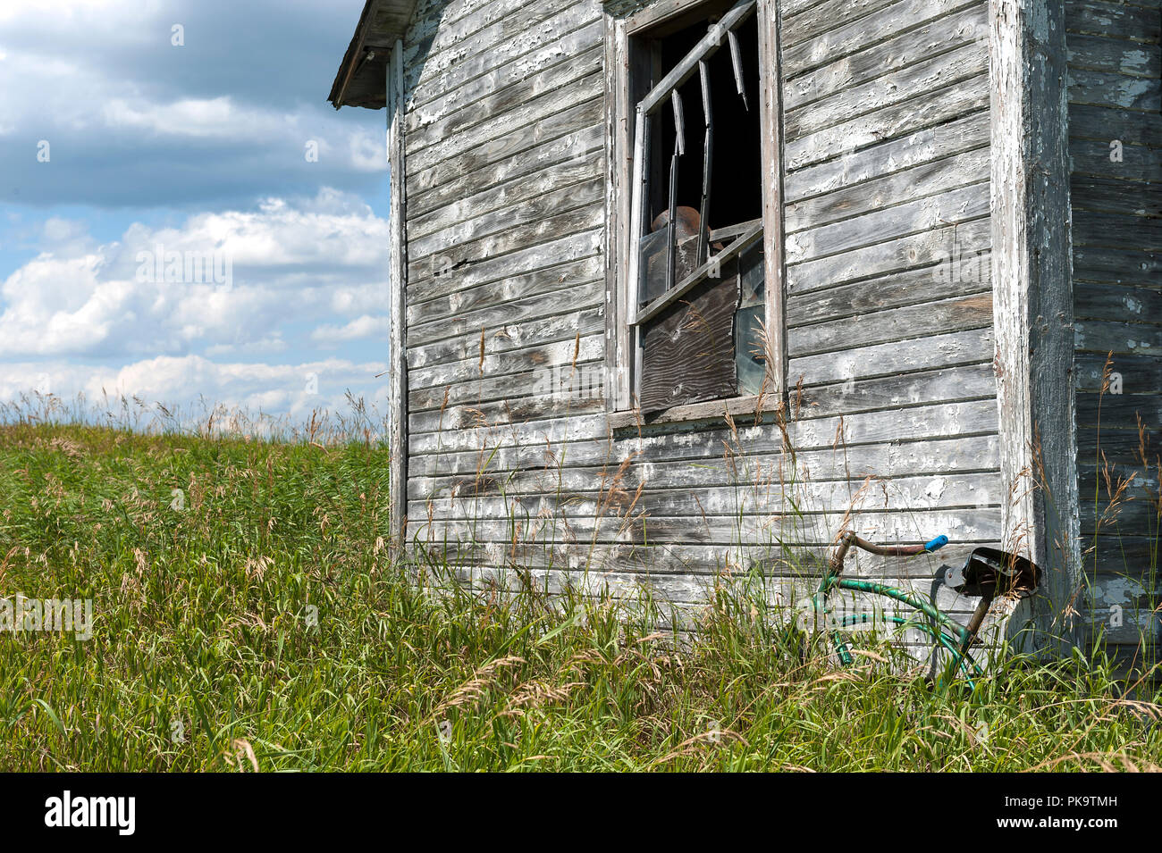 Rurale scena con non verniciata capannone abbandonato e bicicletta Foto Stock