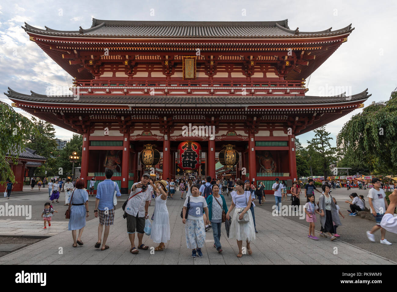 I visitatori del Tempio di Senso-ji in Tokyo posa per le foto di fronte al tempio della gate Hozomon Foto Stock