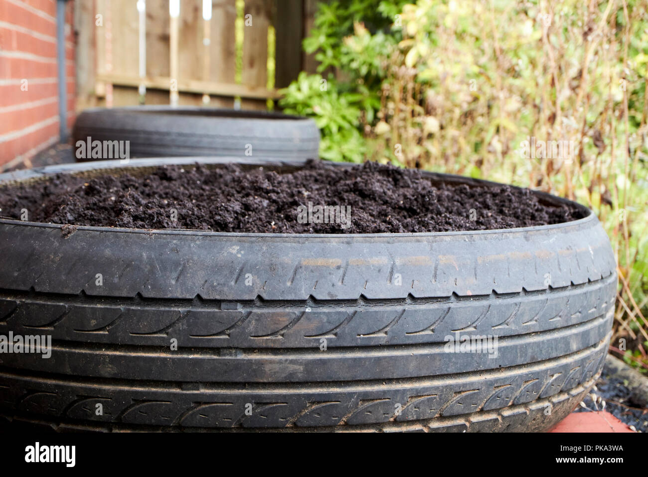 Utilizzando vecchi pneumatici come fioriere in un giardino nel Regno Unito Foto Stock