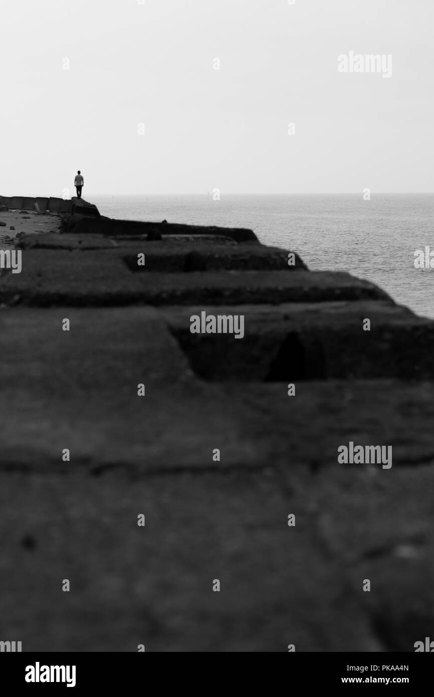Adulto uomo a camminare sulla spiaggia di silhouette a parete Foto Stock